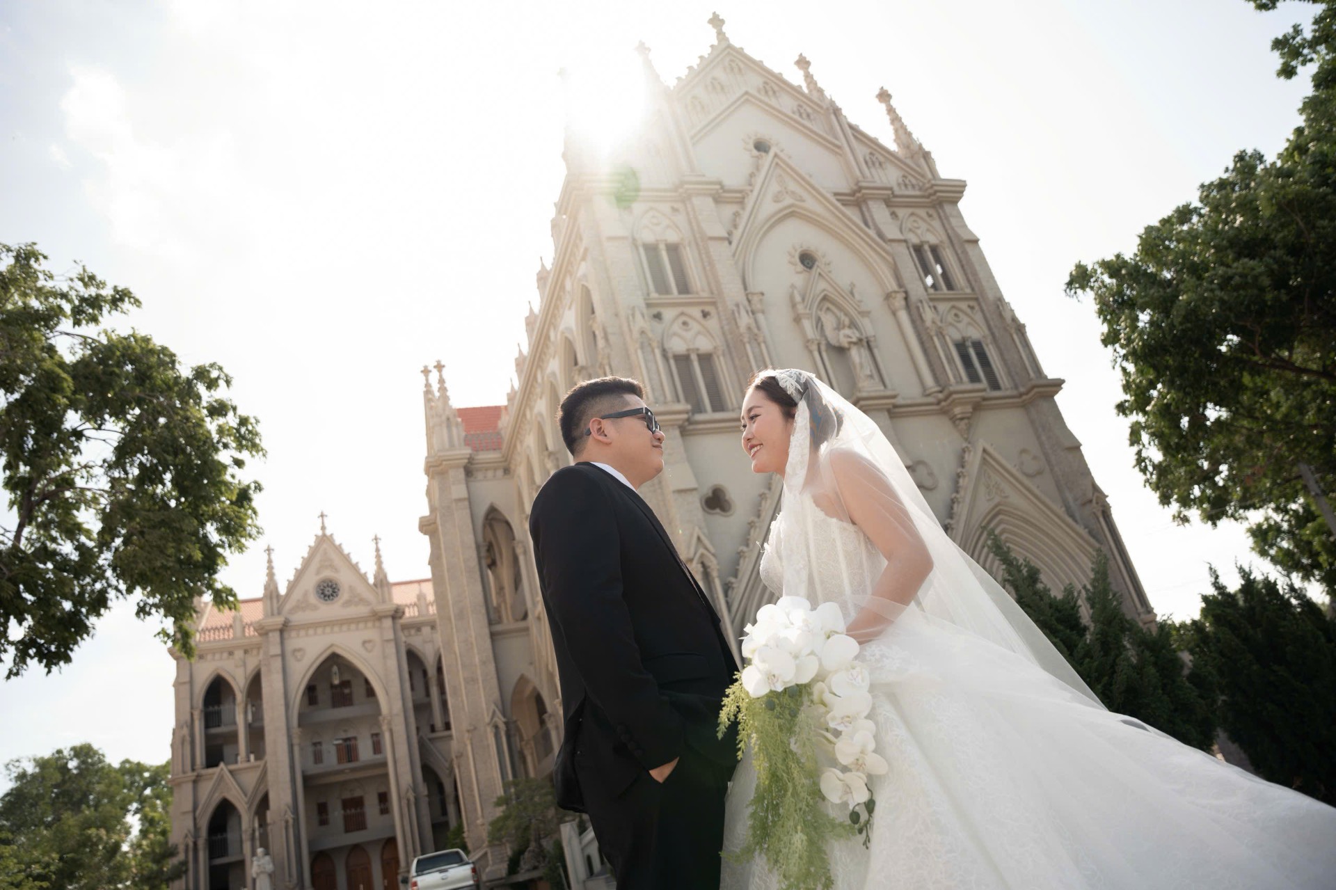 Cô dâu chú rể trao nụ hôn trước nhà thờ Gothic