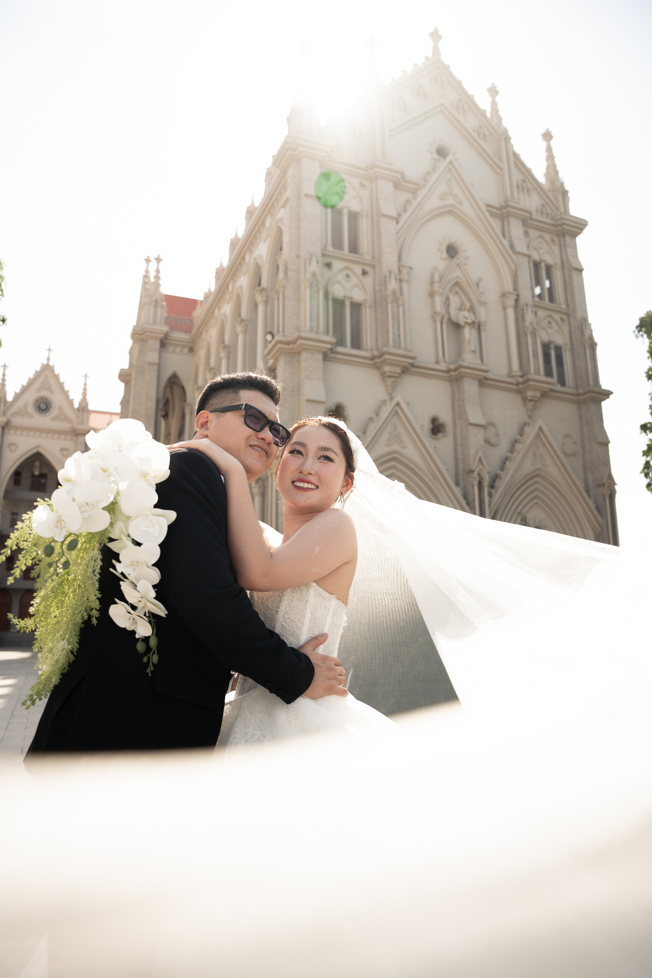 Cô dâu chú rể ôm nhau trước nhà thờ