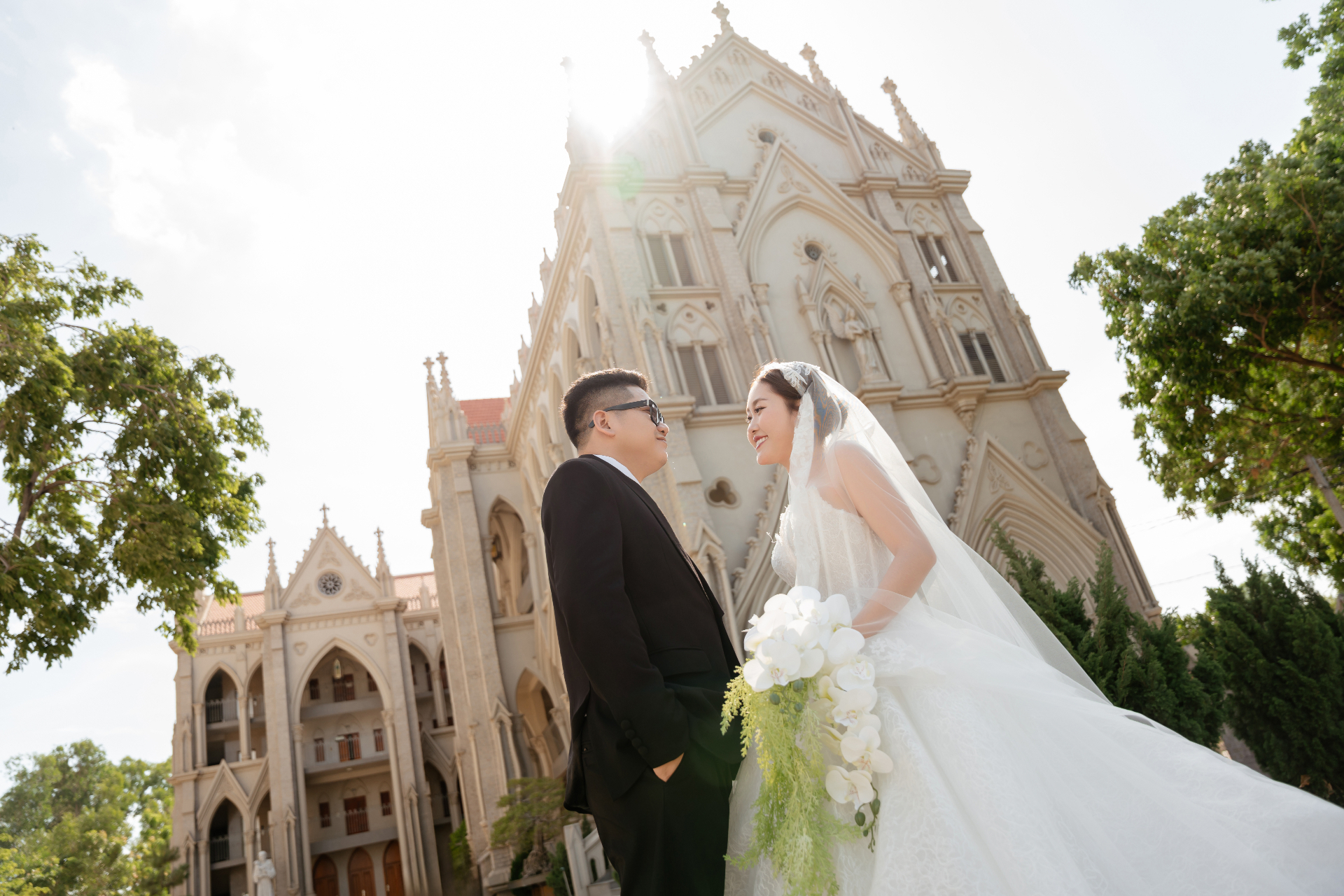 Cô dâu chú rể trao nụ hôn trước nhà thờ Gothic