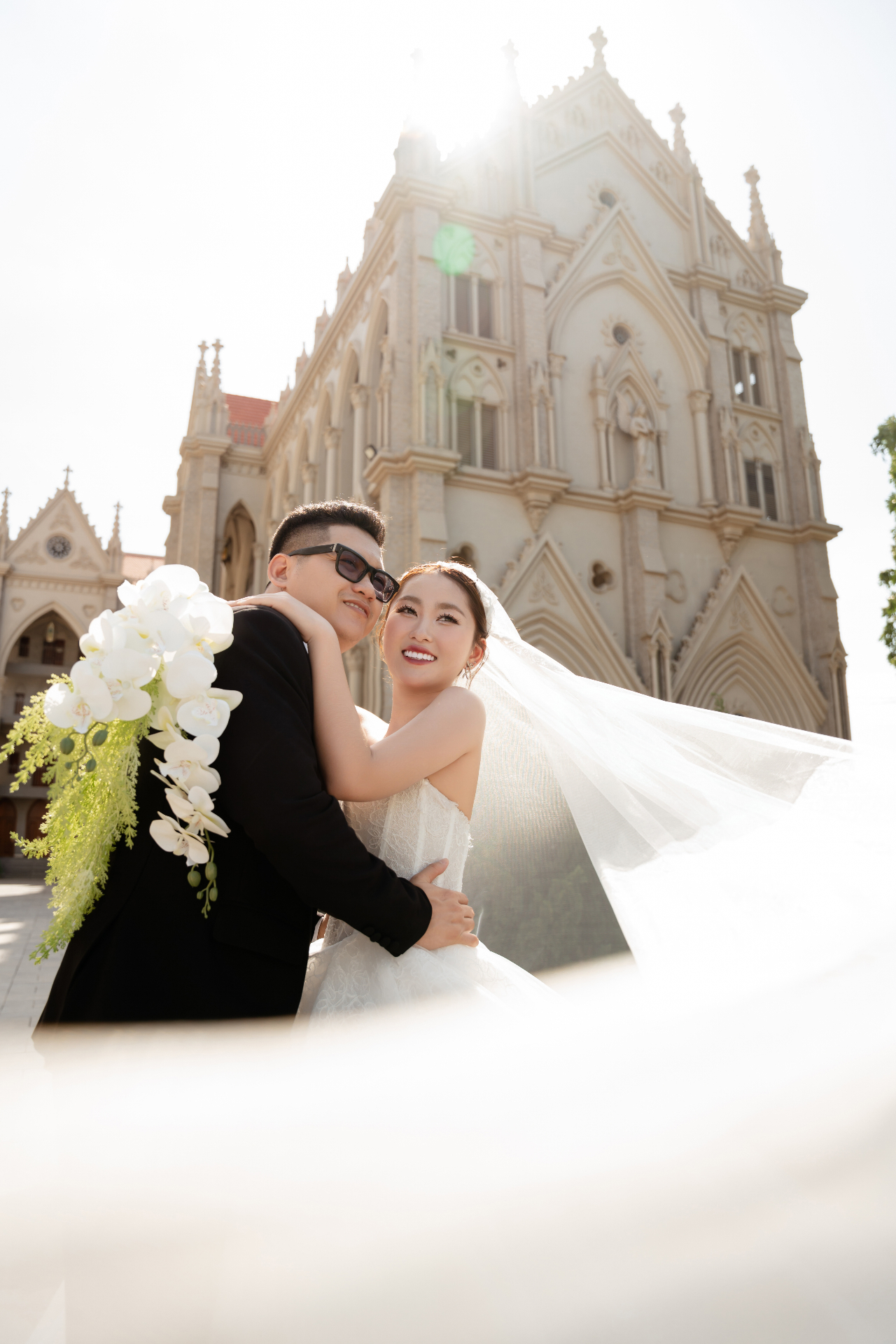 Cô dâu chú rể ôm nhau trước nhà thờ